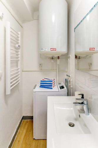La salle de bains blanche est pourvue d'un lavabo et d'un comptoir. dans l'établissement Escale St Charles - 150m de la Gare, vue sur Notre-Dame de la Garde, à Marseille