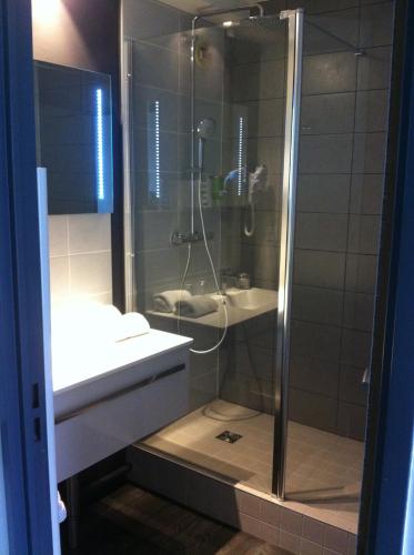 une salle de bain avec douche et lavabo dans l'établissement Golf Hotel Colvert - Room Service Disponible, à Levernois