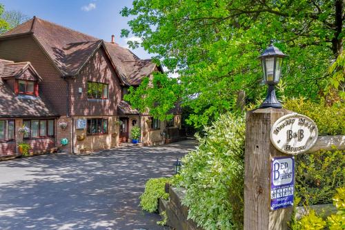 ein Haus mit einem Straßenschild an einem Lichtmast in der Unterkunft Pretty Maid House B&B in Wrotham