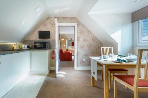 a kitchen and dining room with a table and a room at Pretty Maid House B&B in Wrotham