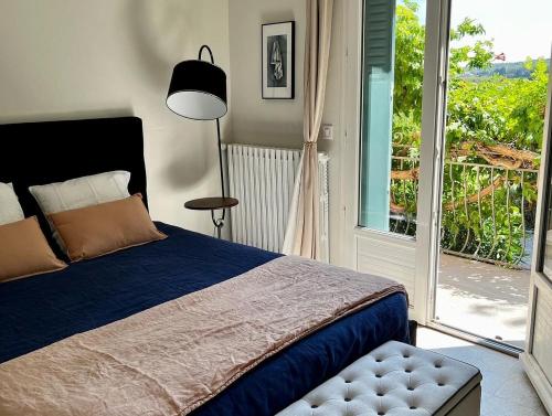 a bedroom with a bed and a large window at Maison d´hôtes Le Mas des Vignes in Rochegude