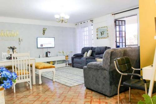 a living room with a couch and a table at Blissful 2 bedroom fully furnished with parking. in Kiambu