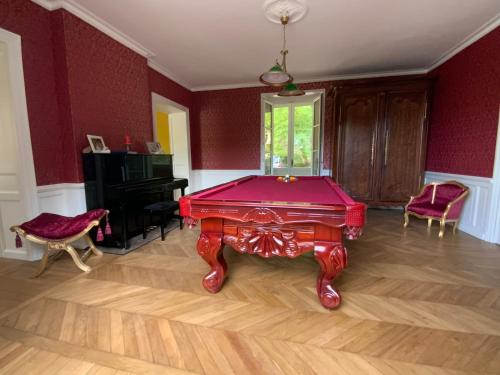 a pool table in a room with red walls at Château d'Argentonesse in Castels
