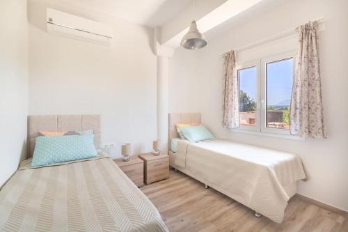 1 Schlafzimmer mit 2 Betten und einem Fenster in der Unterkunft Dimitra's sunny villa in Mirsinokhórion
