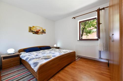 Schlafzimmer mit einem Bett und einem Fenster in der Unterkunft Holiday Home Matan in Saborsko
