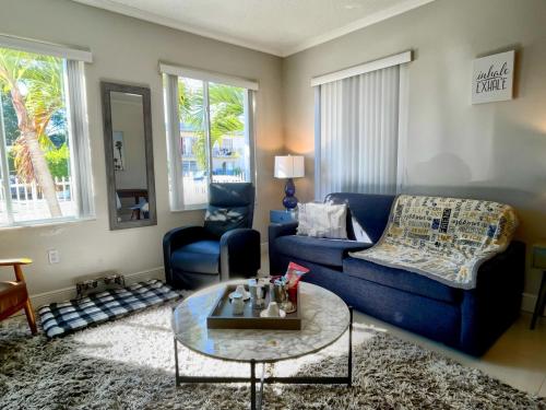 a living room with a blue couch and a table at Marlins Park Suites - Apartment 1 - Calle Ocho Suite in Miami