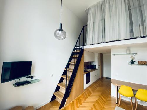 a living room with a staircase and yellow chairs at Loft in city center-Prime rentals in Kaunas