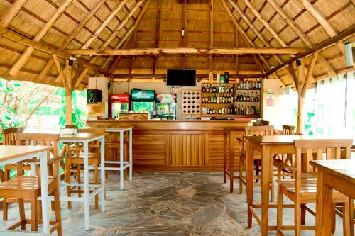a restaurant with a bar with wooden tables and chairs at Kim Hotel in Kigali