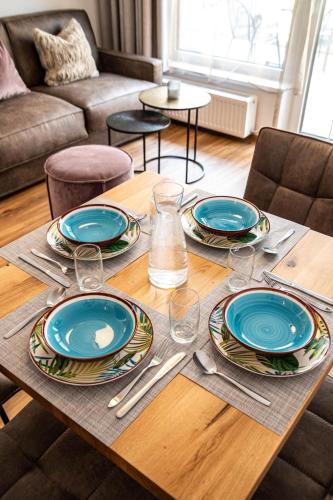 a wooden table with plates and silverware on it at Rustika - Appartements & Spa in Ehrwald