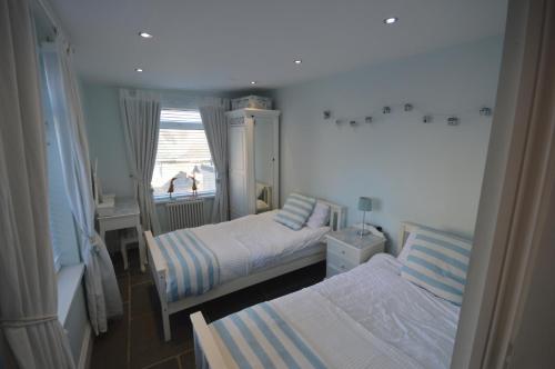 a small bedroom with two beds and a window at Sandridge in Newbiggin-by-the-Sea