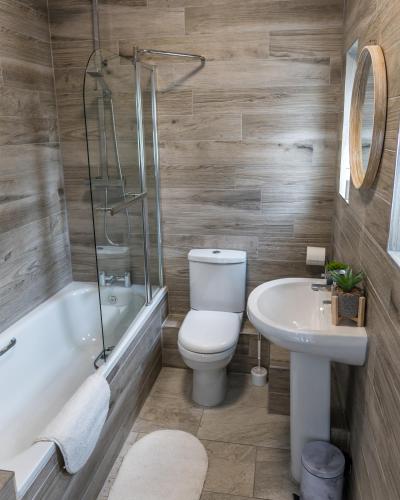 a bathroom with a toilet and a sink at Parke -HotTub- Apartment in Pembroke Dock