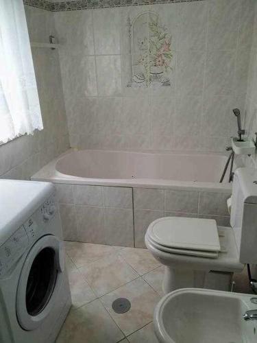a bathroom with a tub and a toilet and a sink at Quinta dos Brazilaves - Ponte de Lima in Ponte de Lima