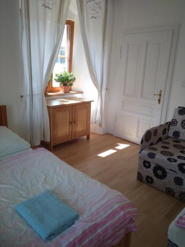 a bedroom with a bed and a couch and a window at Dvůr v Borovné in Borovná