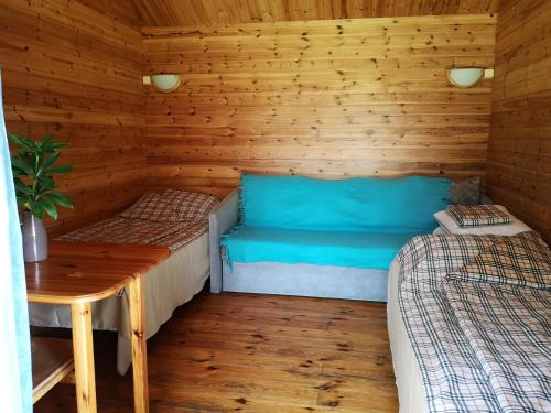 drewniany domek z dwoma łóżkami i stołem w obiekcie Tika Farmstay w mieście Kõrkvere