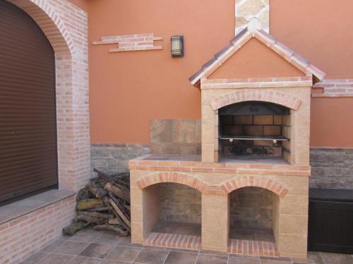 a brick pizza oven on the side of a house at Casa Rural La Calderina in Urda