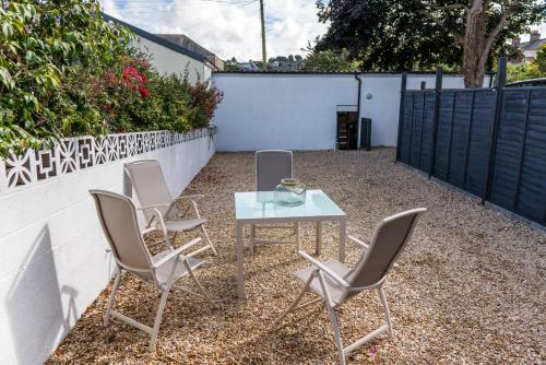 a patio with a table and chairs and a fence at Parke -HotTub- Apartment in Pembroke Dock