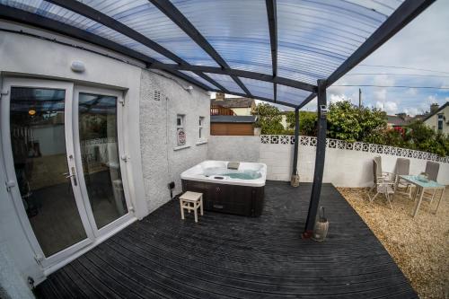 a patio with a hot tub on a deck at Parke -HotTub- Apartment in Pembroke Dock
