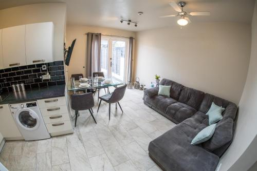 a living room with a couch and a table at Parke -HotTub- Apartment in Pembroke Dock