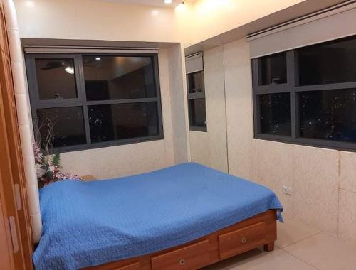 宿务Horizons 101 Condominium Cebu City near Malls的一间卧室设有蓝色的床和2个窗户。