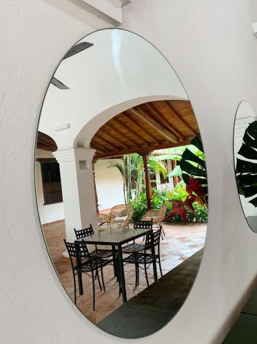 a circular mirror reflecting a table and chairs at Karakali Boutique Hotel in Mompos