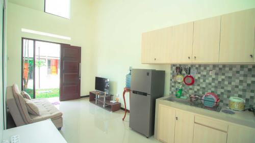 Il comprend un salon et une cuisine équipée d'un réfrigérateur. dans l'établissement Villa Private Pool Syariah Musim Liburan, à Batu