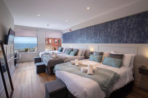 a hotel room with three beds and a television at Ocean View Apartments - Mayfair in Blackpool