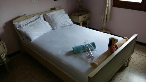 Una cama con una cruz y un osito de peluche. en Kely, en Kineta