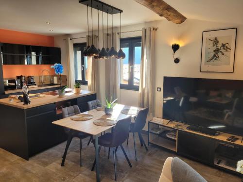 a kitchen and dining room with a table and chairs at gîteduruisseau73, maison entière 80 m2 exposée sud, à 5 minutes en voiture du funiculaire pour Les Arcs Paradiski, , 2 chambres 2 salles de bain avec terrasse et garage in Bourg-Saint-Maurice