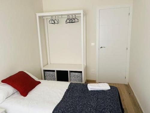 a bedroom with a white bed with a red pillow at PALACIO DE LARRINAGA in Zaragoza