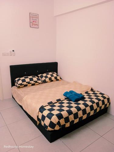 a bed with a black and white checkered blanket at Comfortable18 3R2B 7pax Meritus Perai in Perai