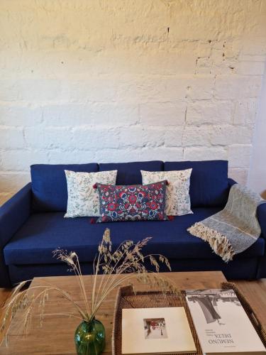 a blue couch in a living room with a table at Pieninė in Ventė