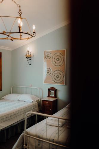 a bedroom with two beds and a chandelier at Forno House in Pereiros