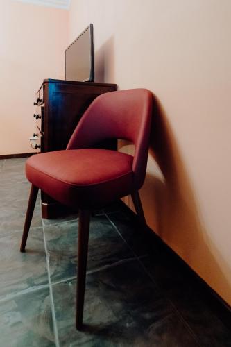 a red chair sitting in front of a desk at Forno House in Pereiros