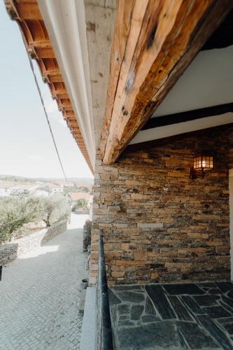 a brick wall of a building with a wooden ceiling at Forno House in Pereiros