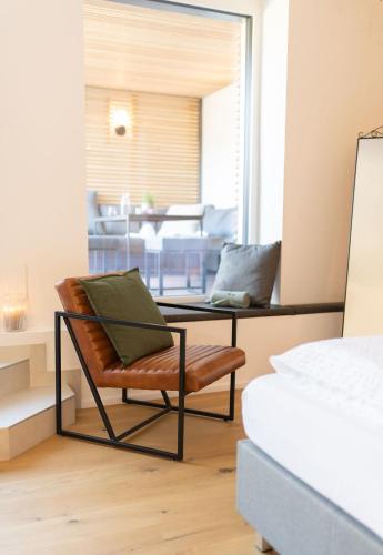 a room with a glass table and a chair at geislerAPPARTMENTS in Gramatneusiedl