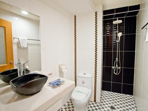 a bathroom with a black sink and a shower at Green Park Commercial Hotel in Tainan