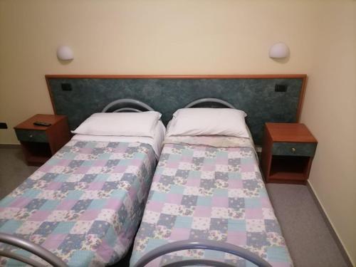 BrognaturoにあるFRATAS AGRITURISMO BELVEDEREのベッドルーム1室(ベッド2台、ナイトスタンド2台付)