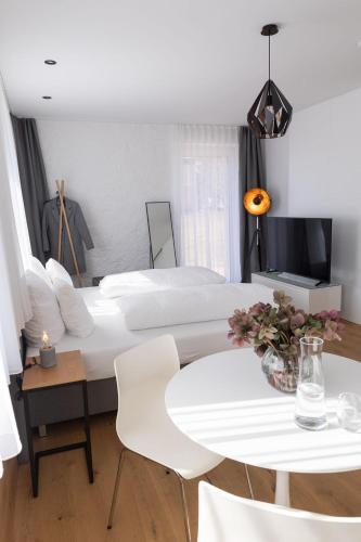 a bedroom with a large bed and a table and chairs at geislerAPPARTMENTS in Gramatneusiedl