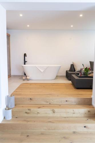 a bathroom with a white tub and a white bath tub at geislerAPPARTMENTS in Gramatneusiedl
