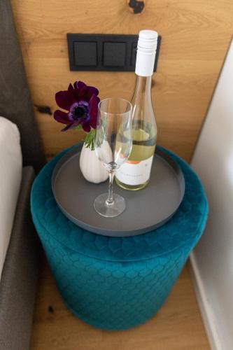 a table with a bottle of wine and a glass at geislerAPPARTMENTS in Gramatneusiedl
