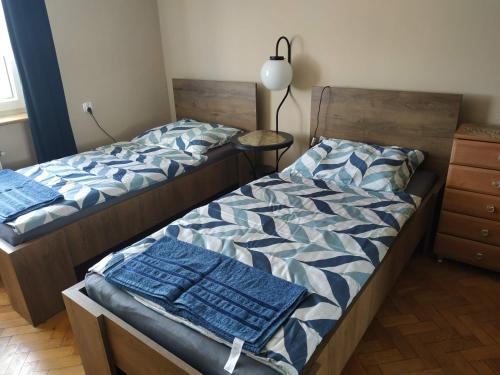 a bedroom with two beds with blue sheets at mieszkanie dwupokojowe w Pucku in Puck