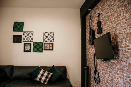 salon z kanapą i ceglaną ścianą w obiekcie Casa Leonardo w mieście Aguascalientes