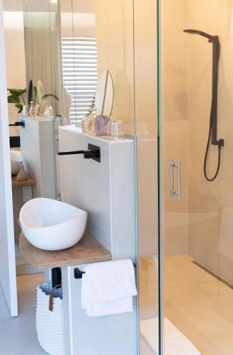 a bathroom with a white sink and a shower at geislerAPPARTMENTS in Gramatneusiedl