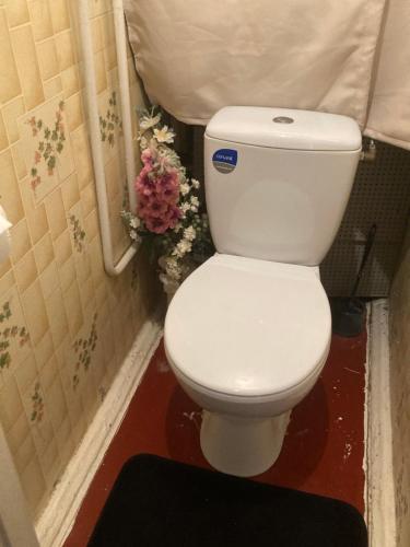 - des toilettes blanches dans une salle de bains fleurie dans l'établissement Back to USSR, à Sillamäe