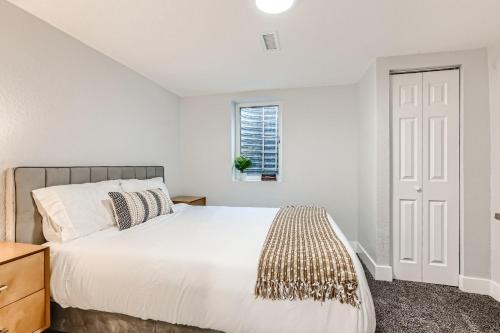 a white bedroom with a bed and a window at Private House Near DT Denver & Mountains, Pet Friendly, Fire Pit, Ping Pong Table, Explore or Relax at this Arvada Retreat in Arvada