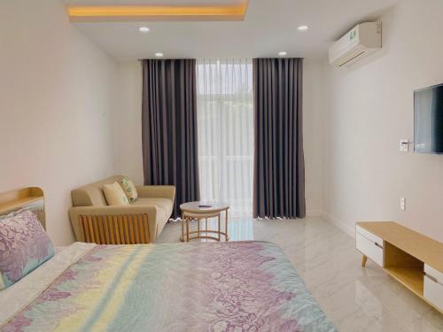 a bedroom with a bed and a couch and a chair at Hotel,Căn Hộ Mũi Né Sea link in Phan Thiet