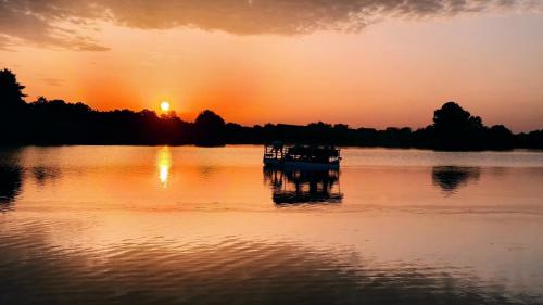 a boat on the water with the sunset in the background at Magaze de Luxe in Gradačac