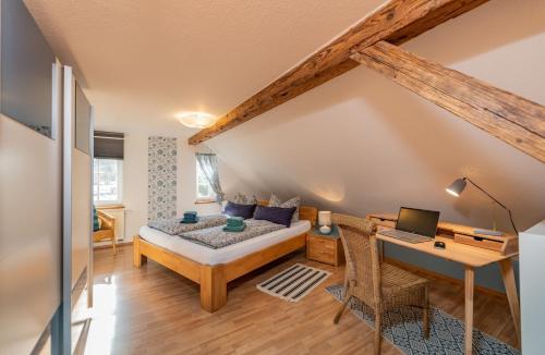 a bedroom with a bed and a desk with a laptop at Im alten Rathaus in Bad Liebenstein