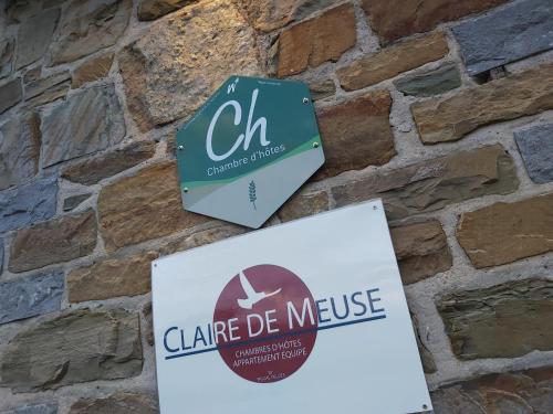 two signs hanging on a brick wall at Nouvelles chambres très confortables avec réfrigérateur in Anhée