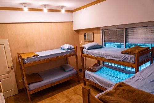a room with three bunk beds and a window at OLO Hostel in Santa Fe